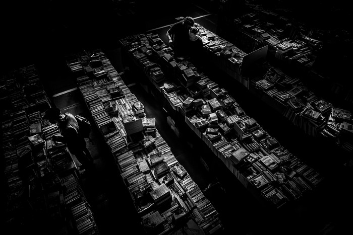 People browsing books in a dimly lit market