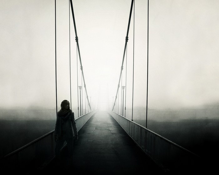 Person on a foggy suspension bridge