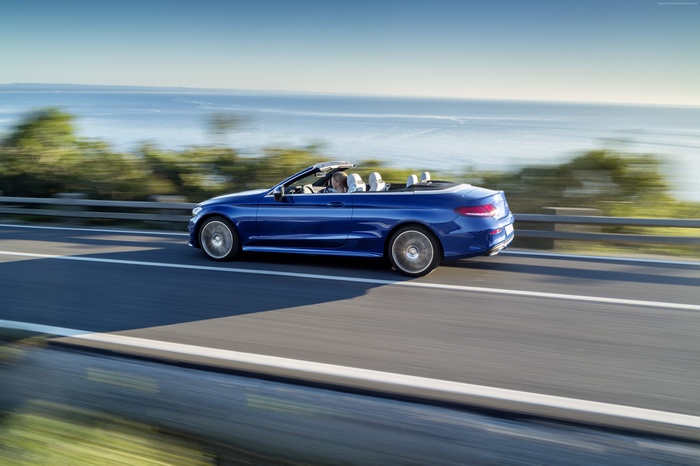 Blue Mercedes-Benz E400 Cabriolet driving on coastal road