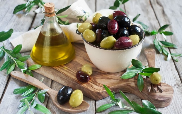 Olives and olive oil on a wooden table