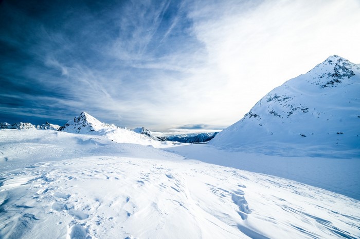 Snowy mountain landscape with dramatic clouds