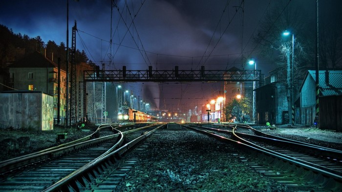 Train tracks at a railyard at night