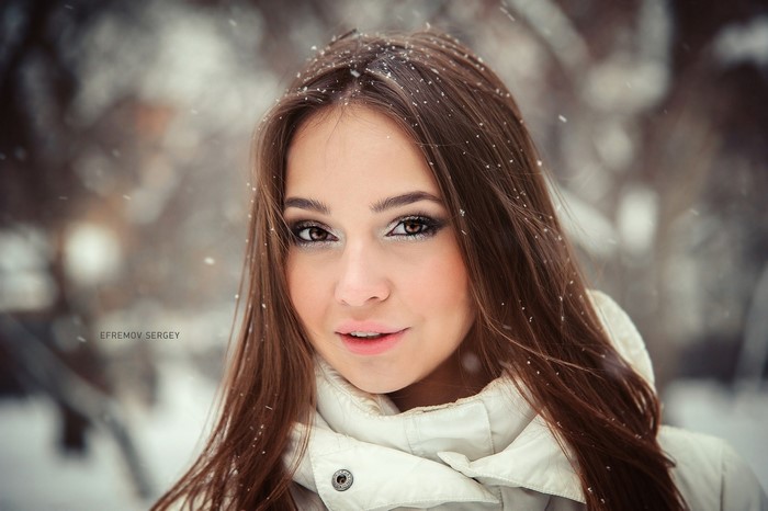 Portrait of a young woman with brown hair in the snow