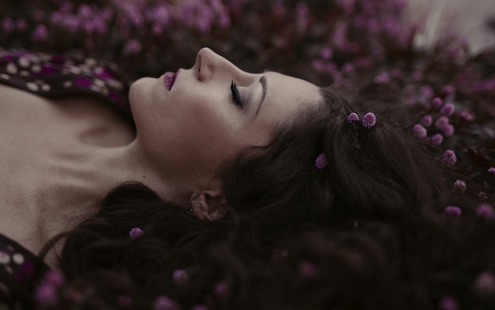 Woman lying down with purple flowers