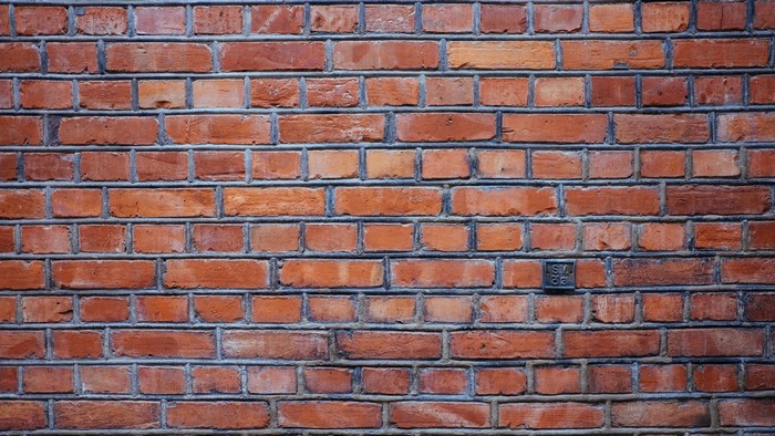 Red brick wall texture with metal plate