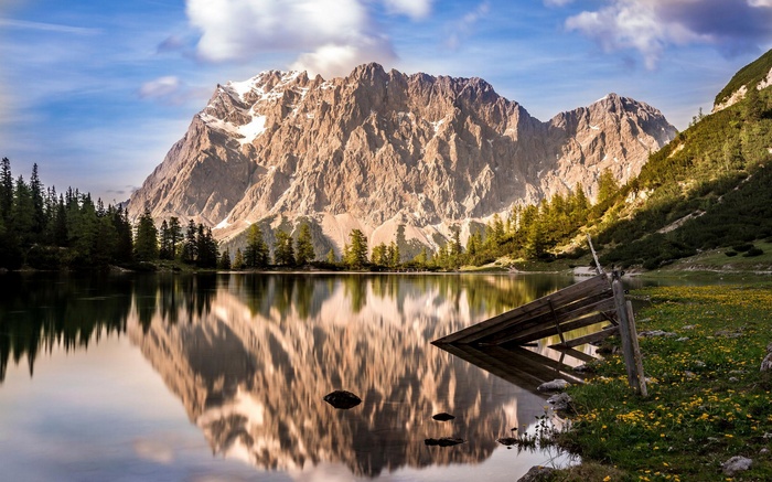 Mountain reflected in a calm lake with wooden fence