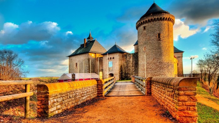 Castle with a bridge and stone walls in autumn