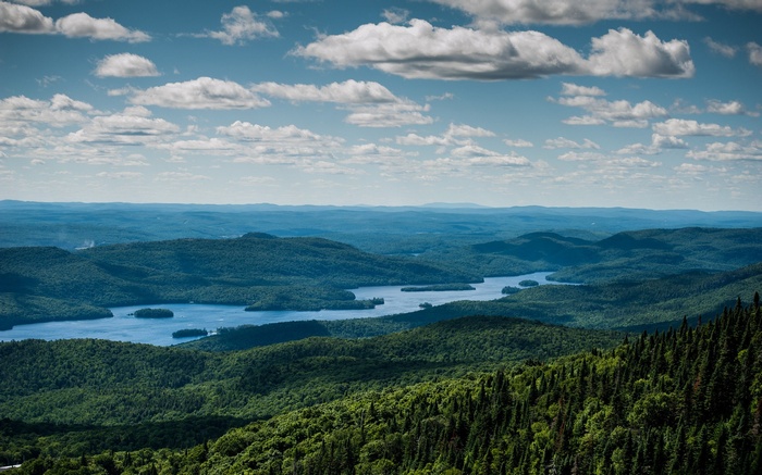 Expansive view of forested mountains and a lake