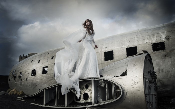 Woman in white dress on airplane wreck