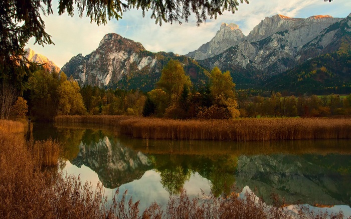 Autumn lake reflecting mountains and trees