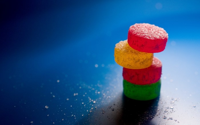 Stack of colorful gummy candies with sugar