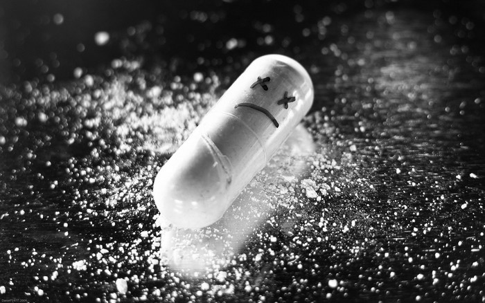 A single pill with a sad face drawn on it