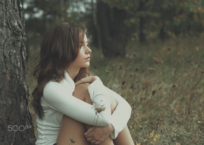 Contemplative Woman Sitting by the Tree in Nature