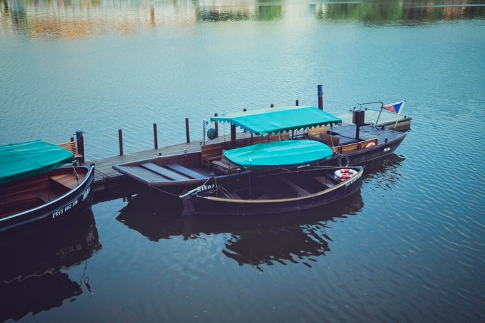 Boats docked at a wooden pier on a calm lake