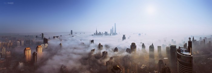 Panoramic view of Shanghai skyscrapers shrouded in fog at sunrise