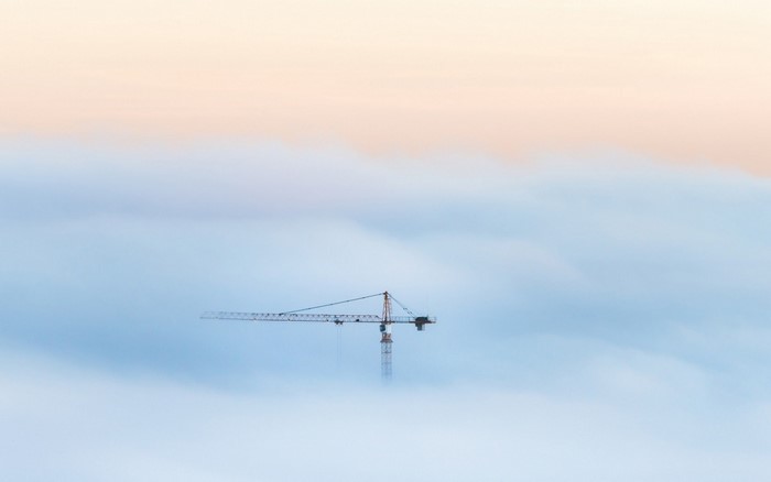 Crane machine above the clouds at sunrise