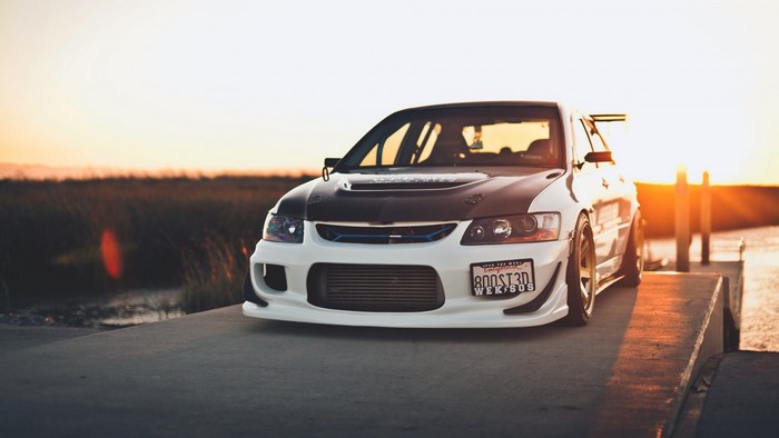 White Mitsubishi Lancer Evolution with Carbon Fiber Hood at Sunset