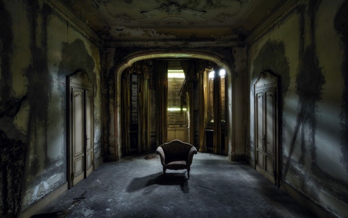 Abandoned mansion room with single chair