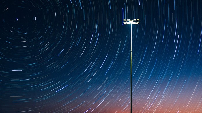 Star trails around a light pole at night
