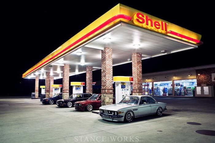 BMW cars at a Shell gas station at night