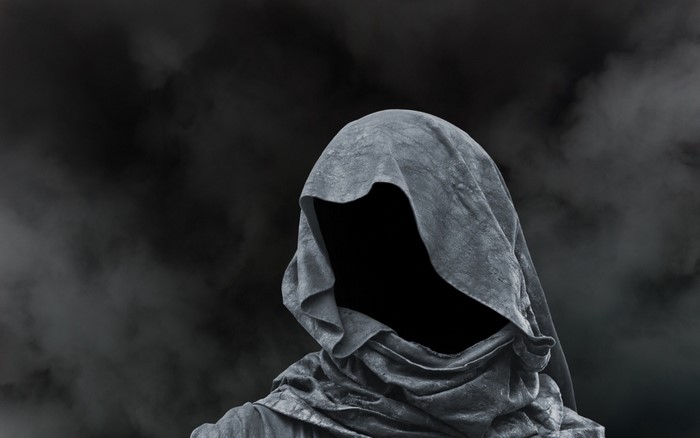 Monochrome sculpture of a hooded, faceless figure