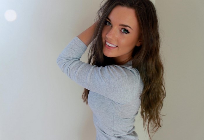 Woman with long brown hair and green eyes smiling