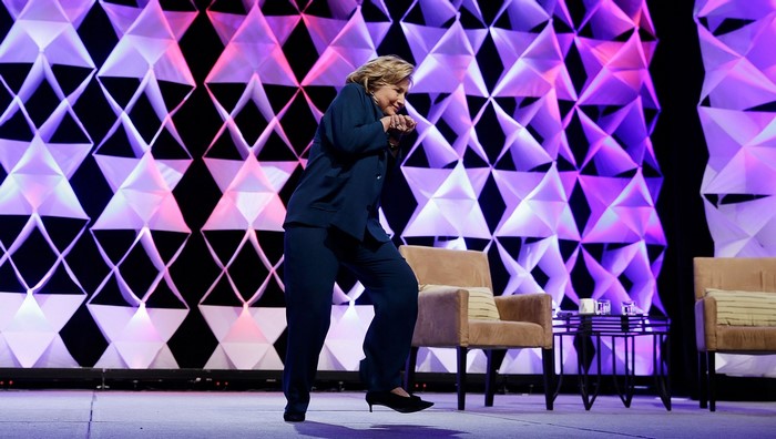 Hillary Clinton on stage with geometric background