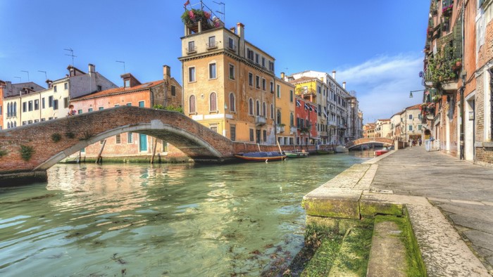 Venice canal with a brick bridge and colorful buildings