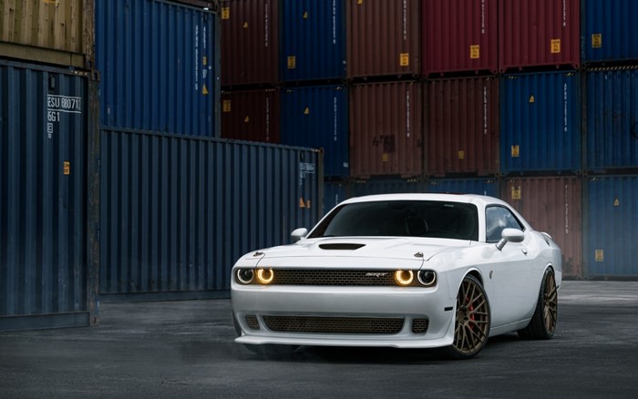 White Dodge Challenger SRT parked near shipping containers