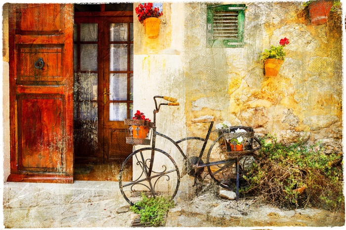 Vintage bicycle with flowers in front of an old house