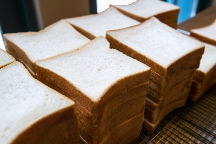 Stacks of white bread slices on a cooling rack