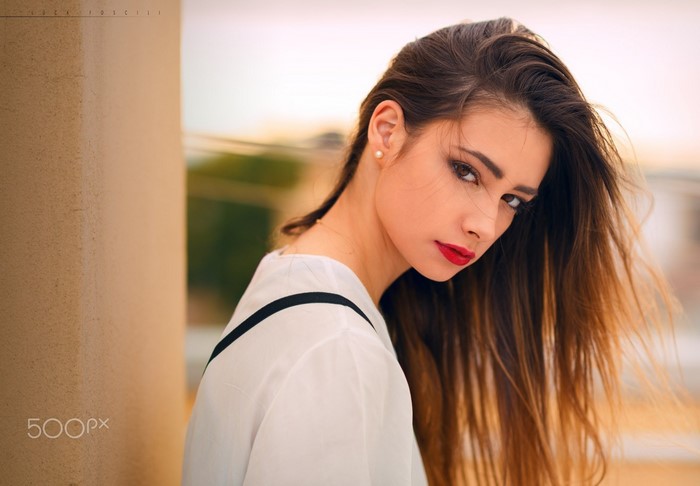 Portrait of a woman with long brown hair and red lipstick