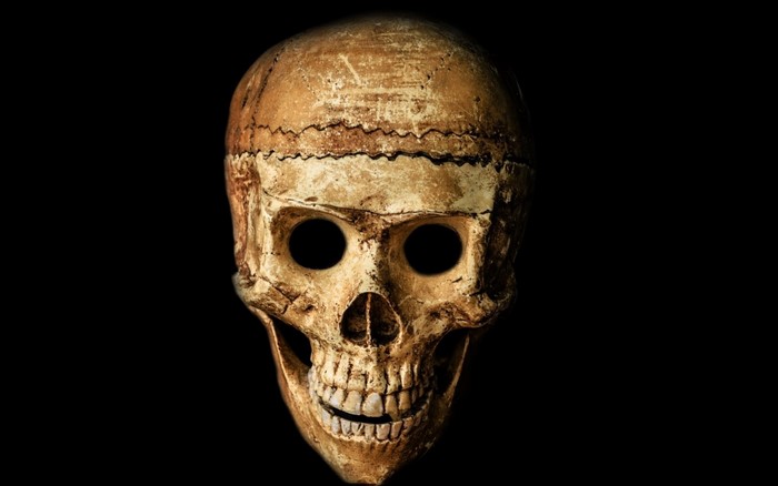 A weathered skull mask with empty eye sockets
