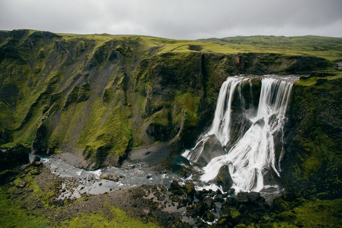 Waterfall cascading down a moss-covered cliff in Iceland