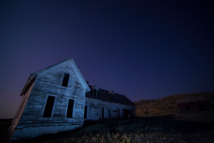 Abandoned house under a starry night sky