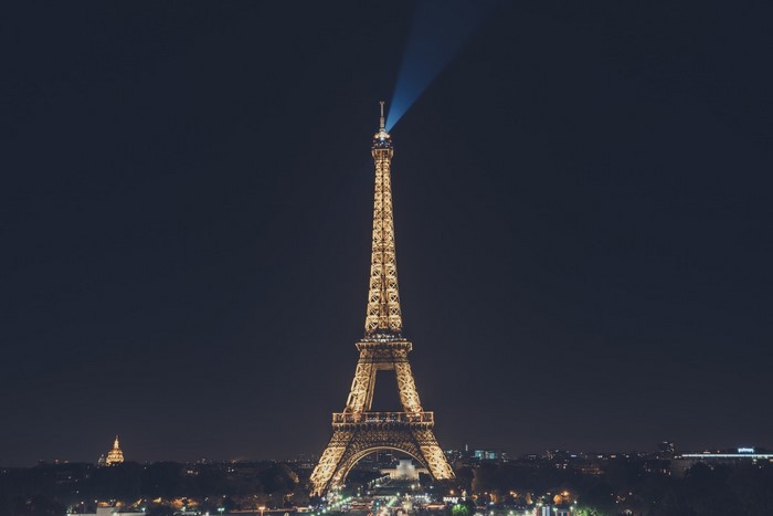 Eiffel Tower illuminated at night with a beam of light