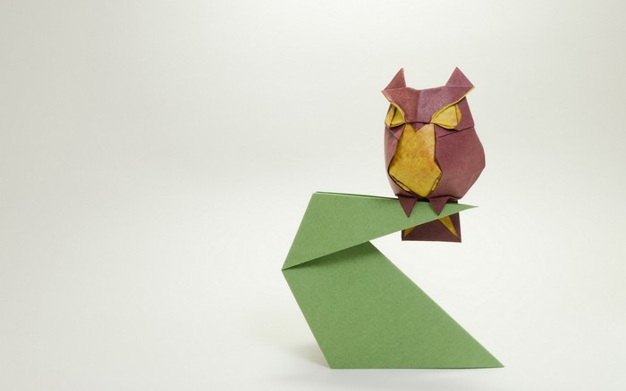 Origami owl perched on a green paper branch