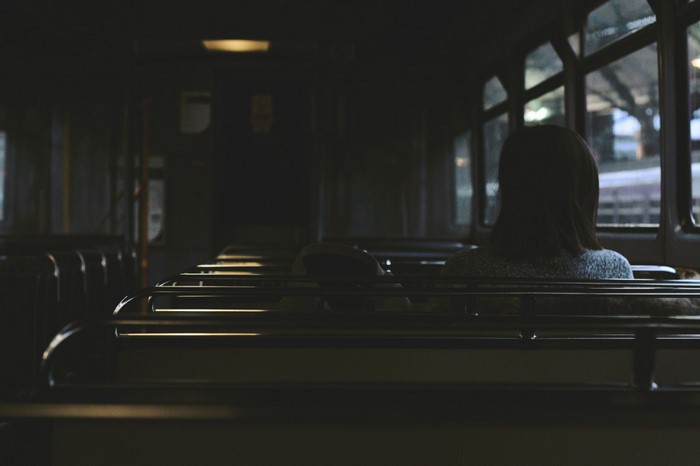 Woman sitting on a bus at night