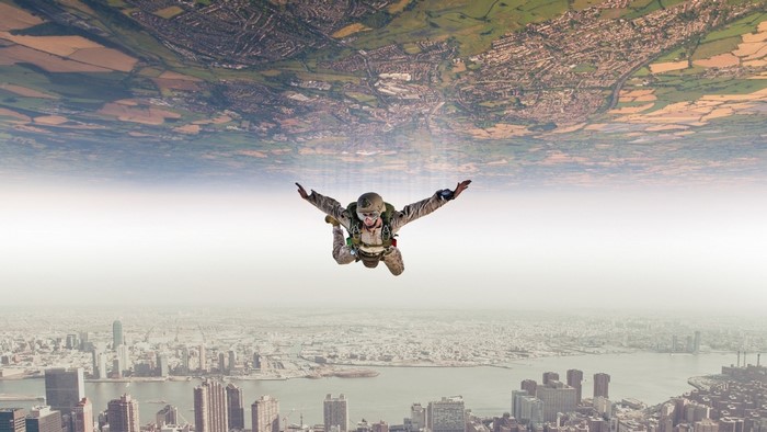 Skydiver falling between two cityscapes