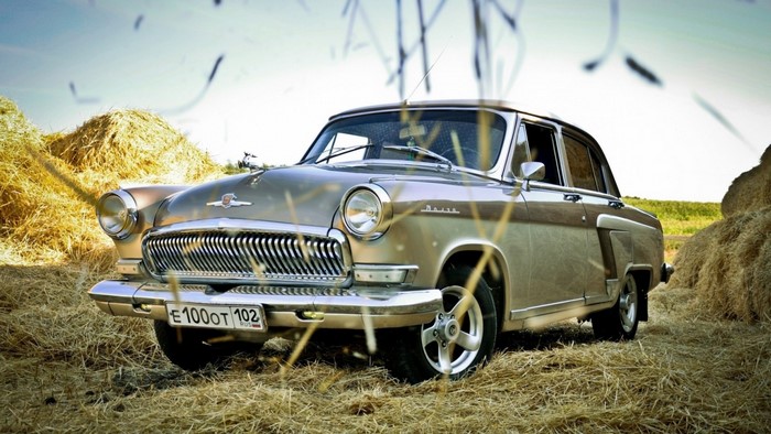GAZ 21 Volga vintage car in a field with hay bales