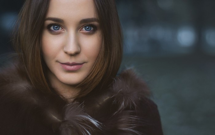 Woman with blue eyes wearing a fur coat