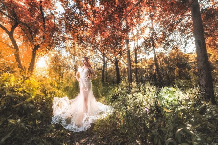 Woman in a white dress in an autumn forest