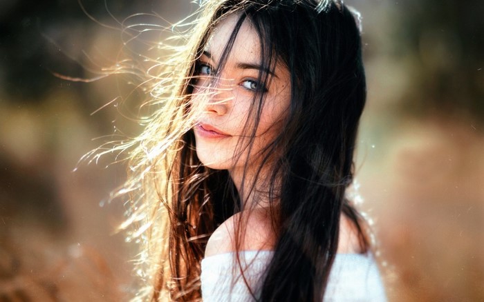 Woman with long brown hair in sunlight