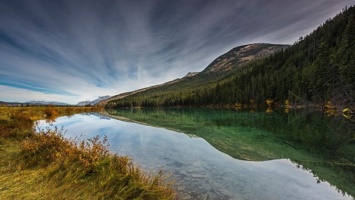 Mountain lake reflection in fall with pine forest