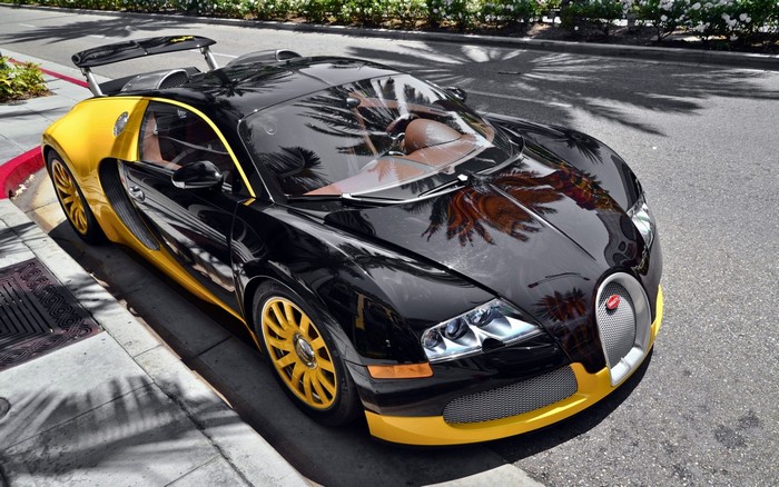Black and yellow Bugatti Veyron parked on a street