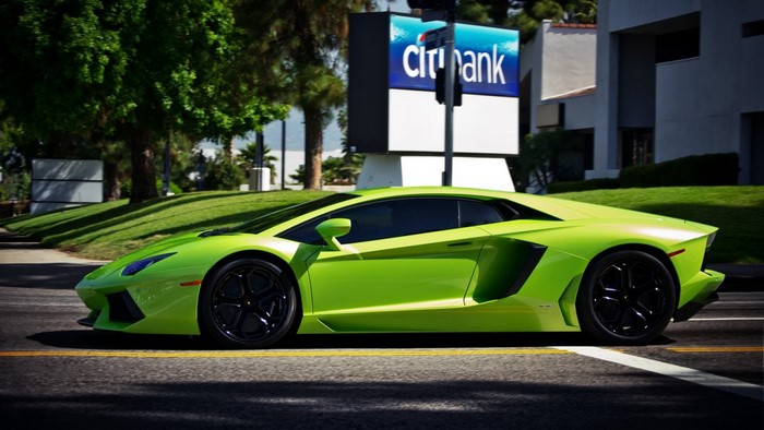 Lime Green Lamborghini Aventador driving on road