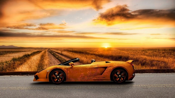 Orange Lamborghini Gallardo convertible on a road at sunset