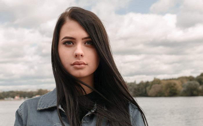 Woman with long dark hair wearing a denim jacket