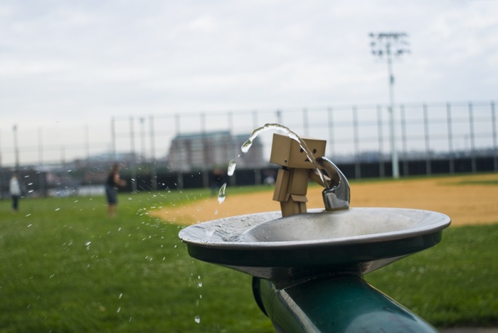 Danbo at a water fountain on a baseball field