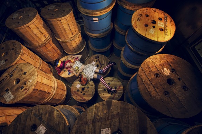 Woman in costume lying on spools